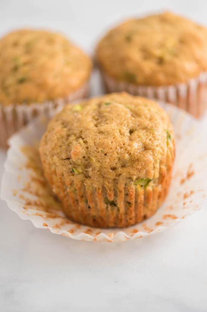 zucchini muffin with two muffins behind it