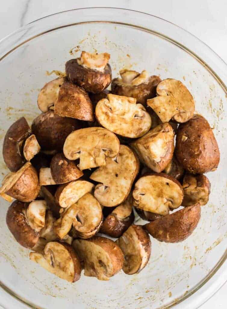 mushrooms in a bowl mixed with the seasoning ingredients before cooking