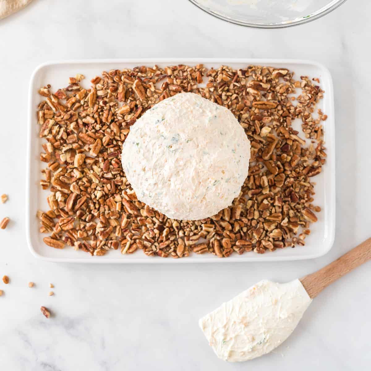 cheese ball on a plate of pecan pieces