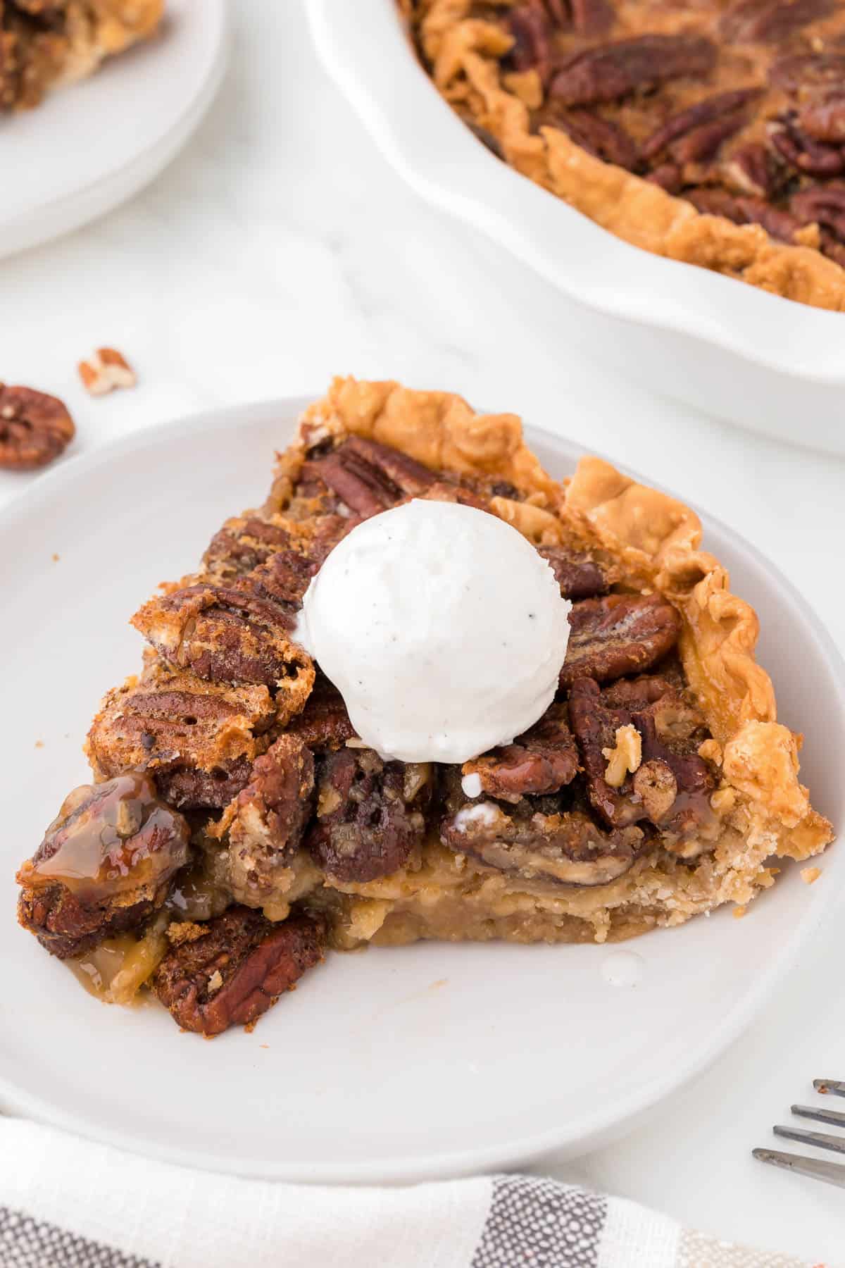 slice of maple pecan pie topped with a scoop of ice cream