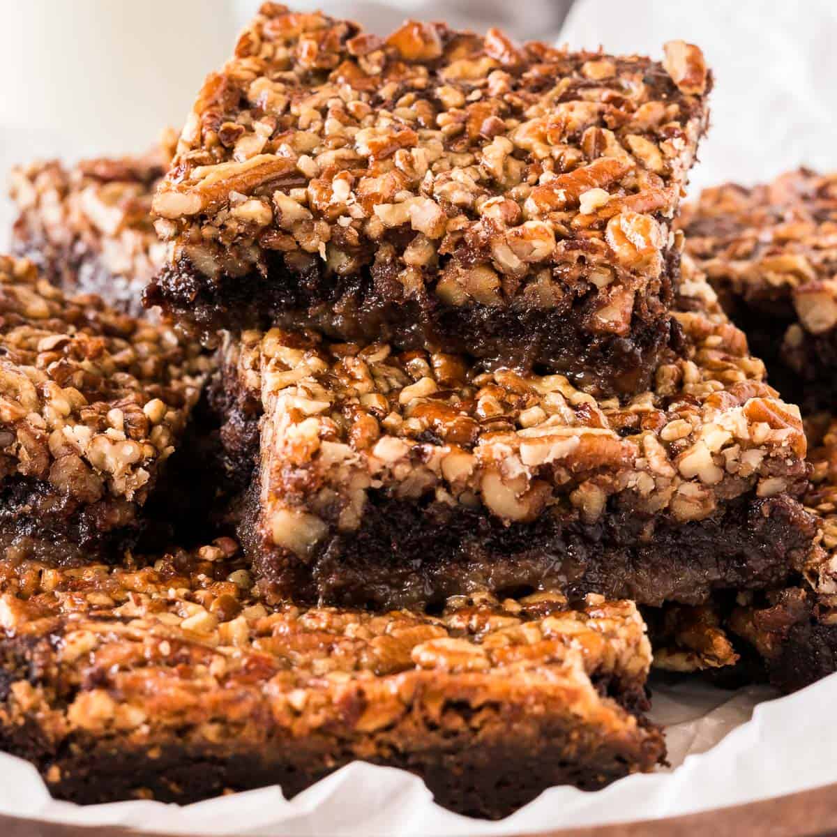 pecan pie brownies cut into squares and stacked on a plate