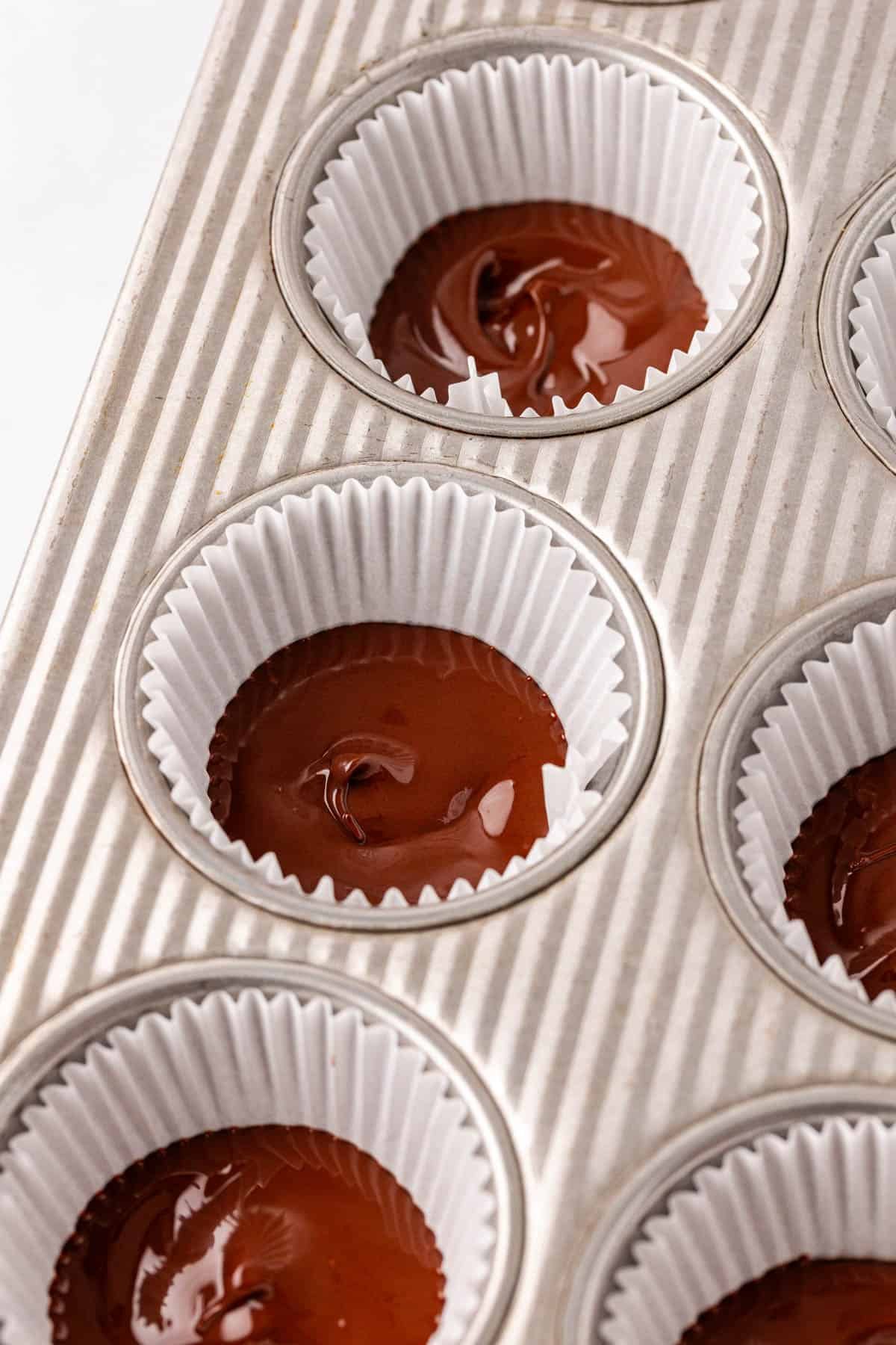melted chocolate in a muffin tin liner