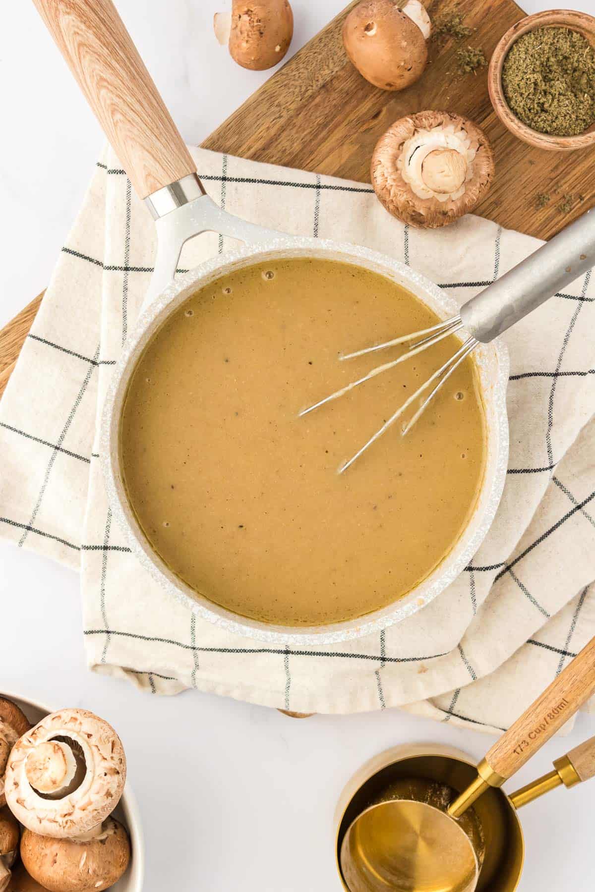 whisking the gravy in a sauce pan