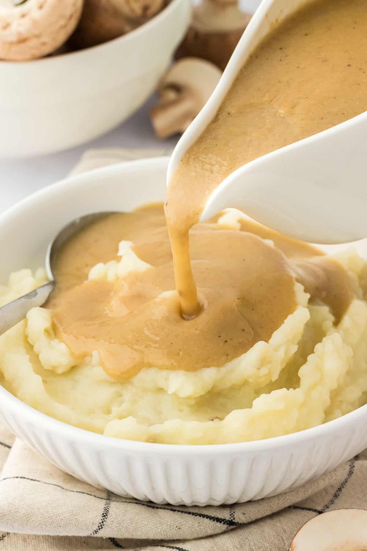 pouring gravy over mashed potatoes