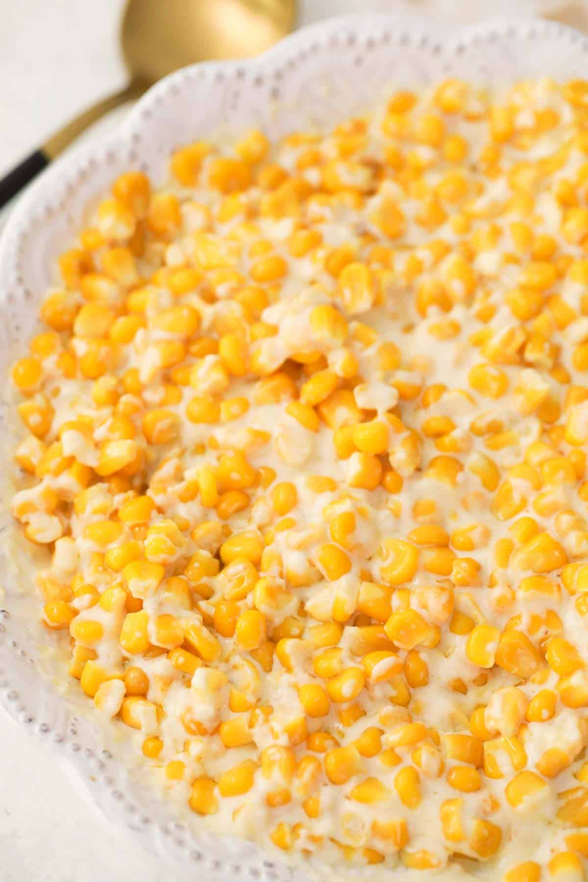 creamed corn with cream cheese in a white serving dish