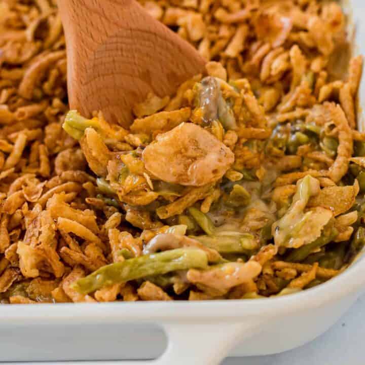 taking a scoop of green bean casserole from the dish