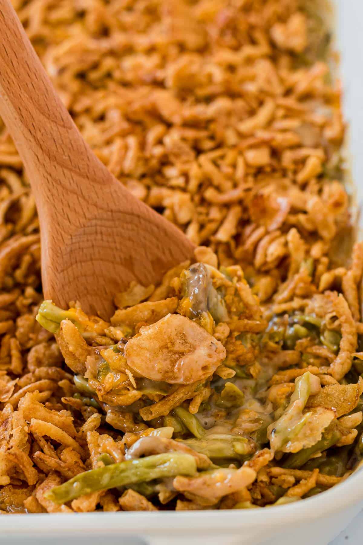 taking a scoop of green bean casserole from the dish