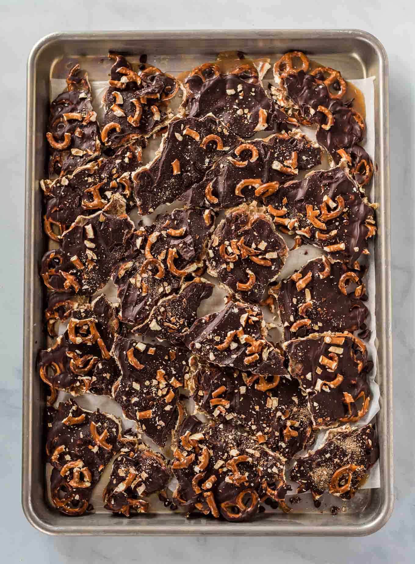 the finished chocolate caramel pretzel bars broken up on the baking sheet