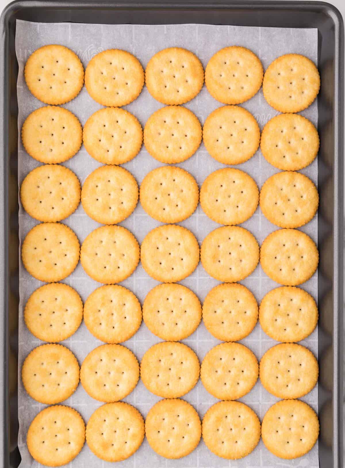 ritz crackers lined up on a baking sheet