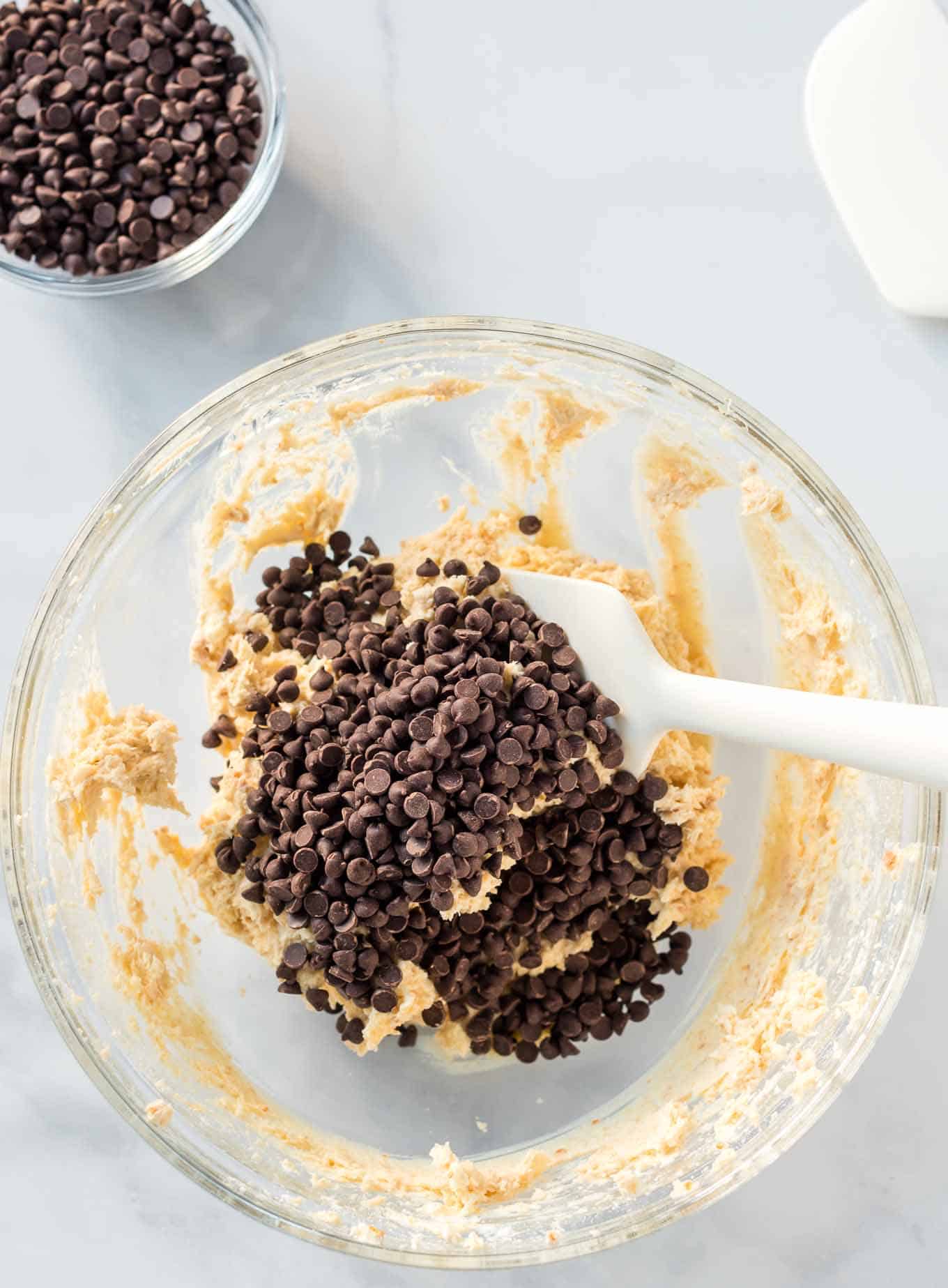 cheese ball ingredients topped with mini chocolate chips in a glass bowl