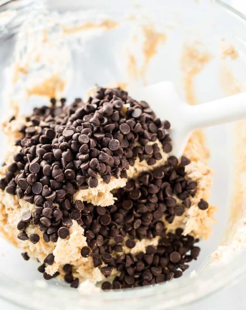 cheese ball ingredients topped with mini chocolate chips in a glass bowl