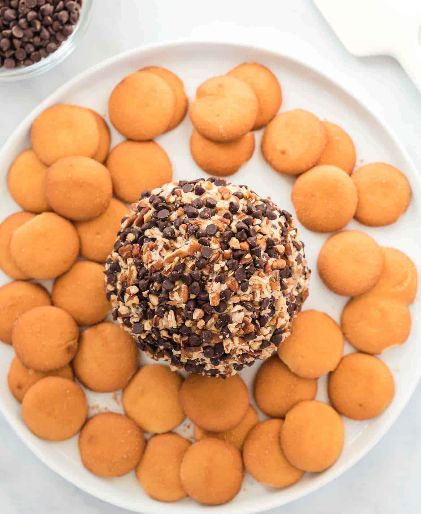 chocolate chip cheese ball on a white plate surrounded by nilla wafers
