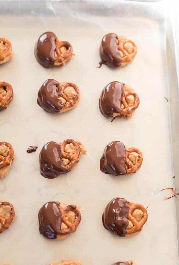 a sheet pan with pretzels dipped in melted chocolate