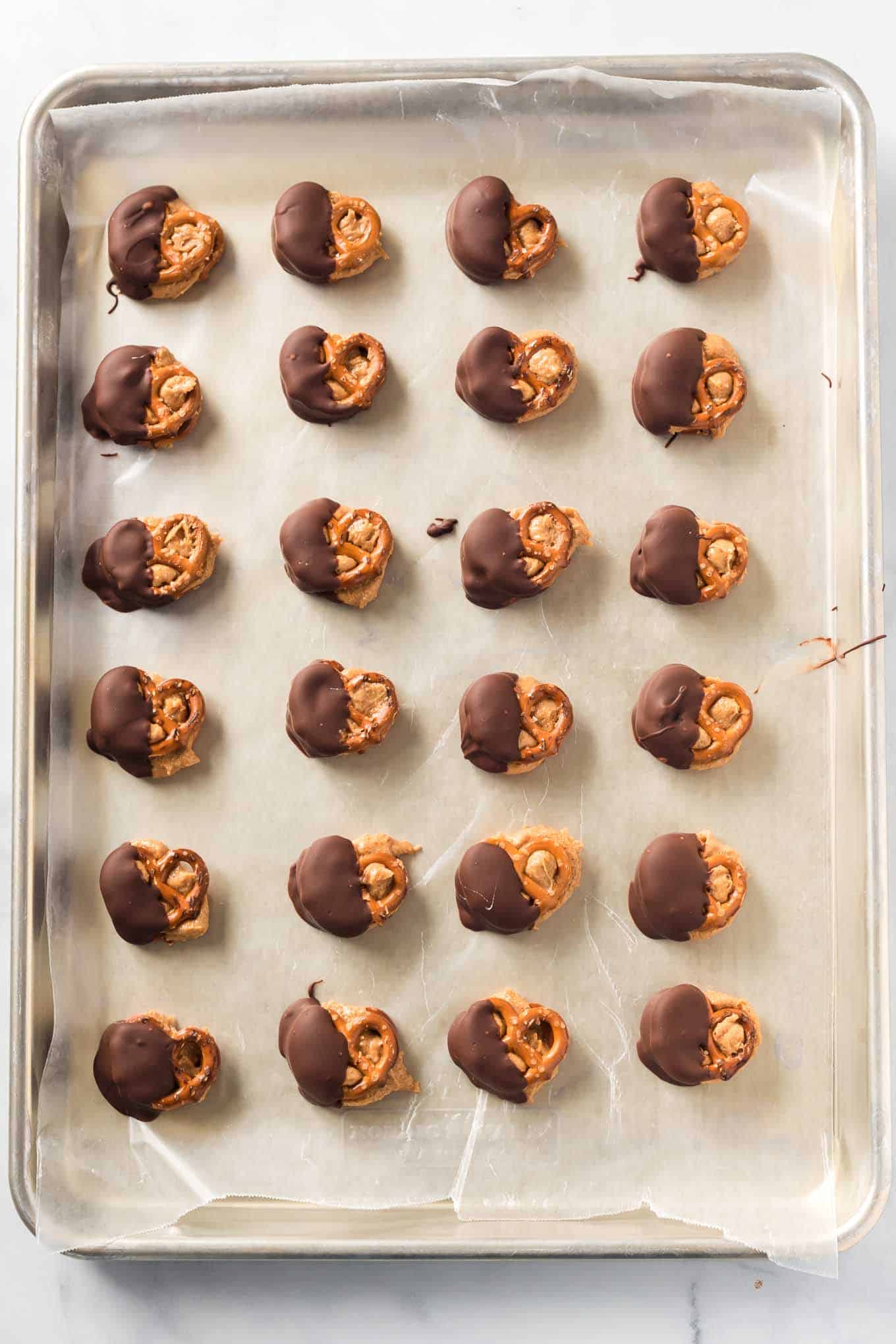 a sheet pan with pretzels dipped in melted chocolate after hardening