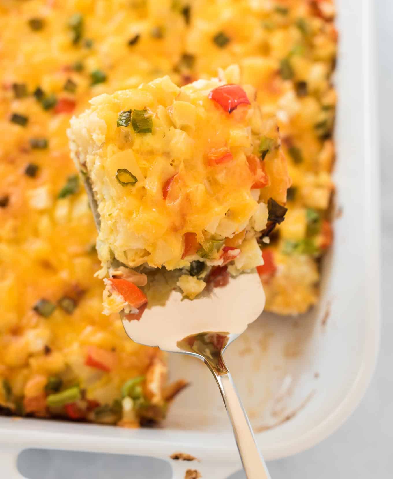 a spatula holding a square of casserole over the dish