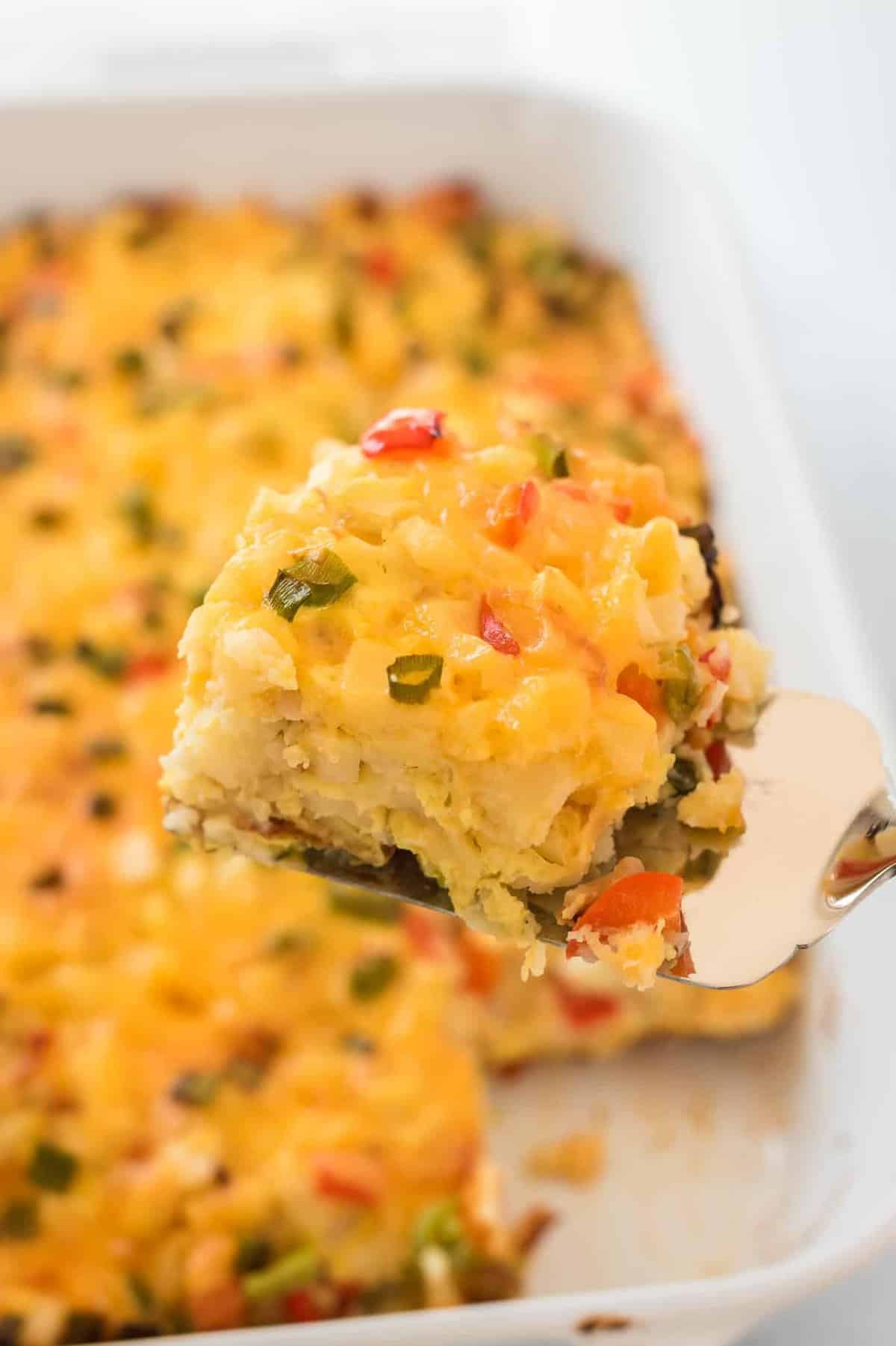 a spatula holding a square of casserole over the dish