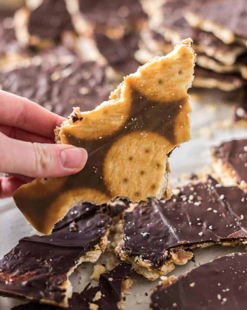 a hand holding a christmas shaped piece of toffee