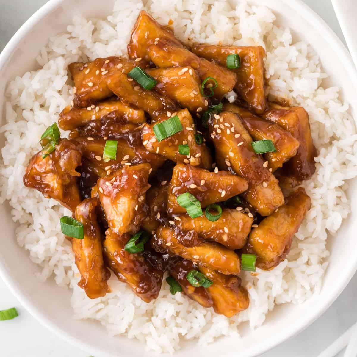 teriyaki tofu triangles over white rice in a bowl