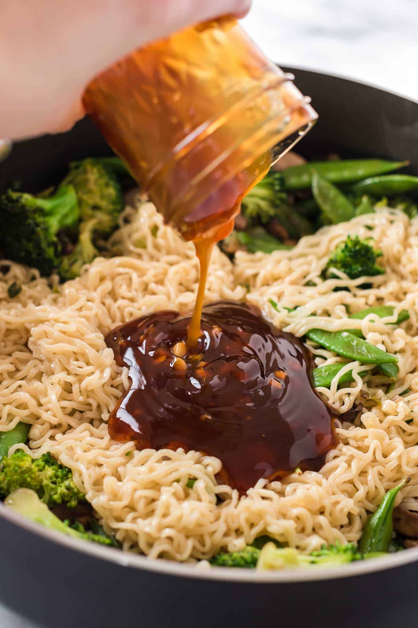 teriyaki sauce being poured onto a stir fry