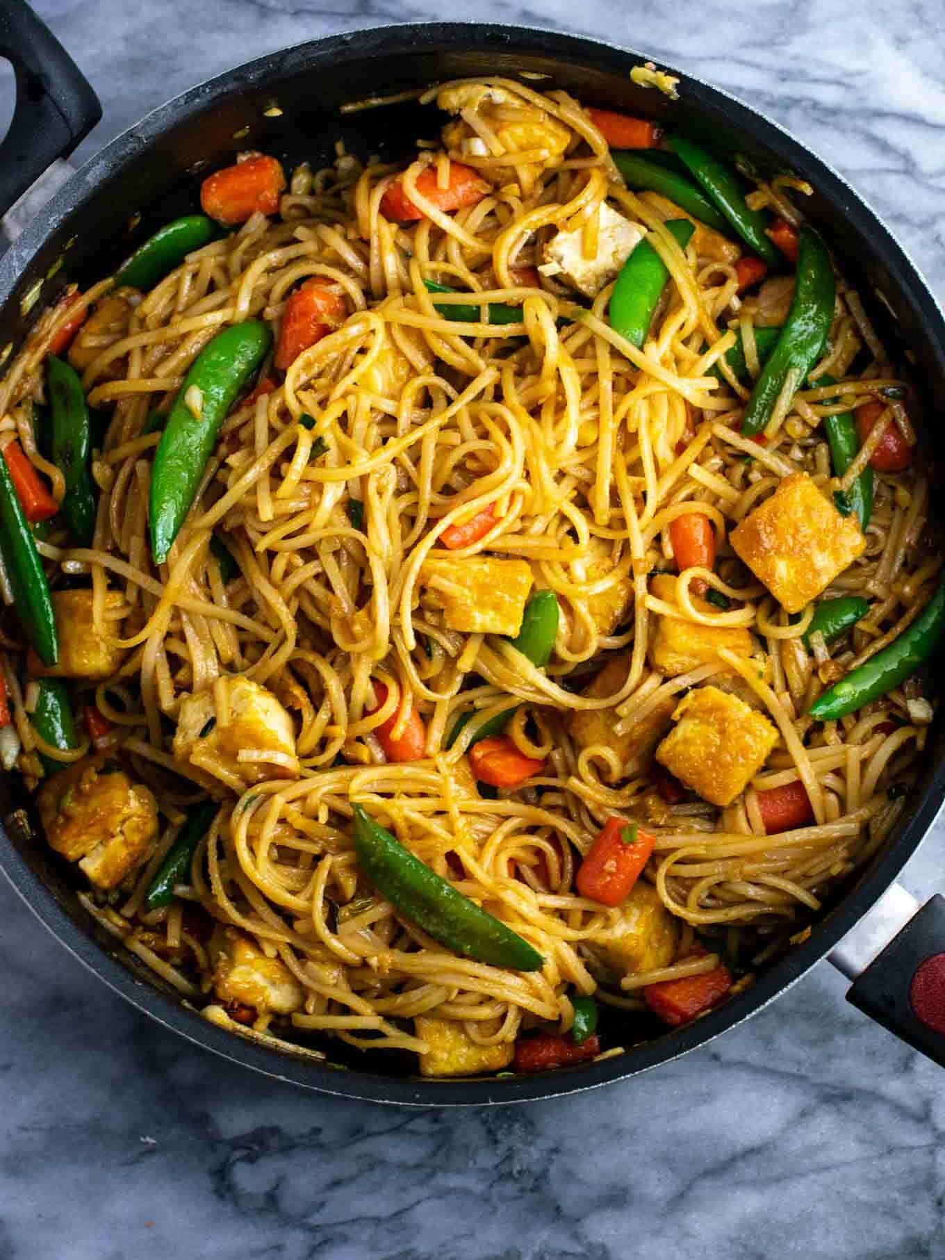Vegan stir fry noodles with sugar snap peas and carrots. Homemade 3 ingredient stir fry sauce makes this taste amazing! #tofu #stirfrynoodles #stirfry #vegan #dinner #stirfryrecipe #vegetarian #tofustirfy