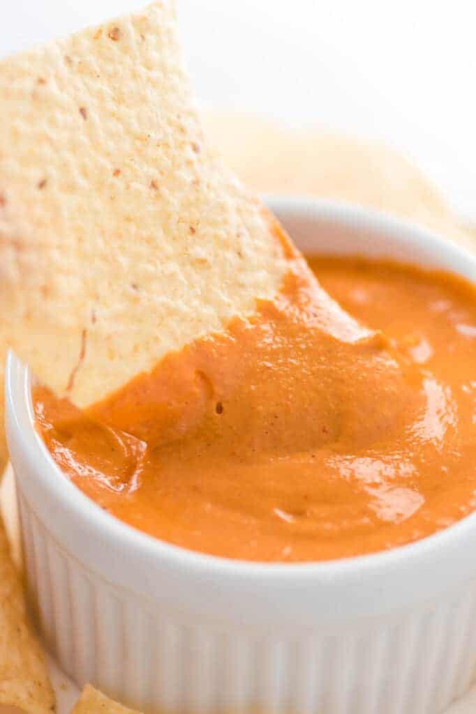 chip dipped in vegan queso