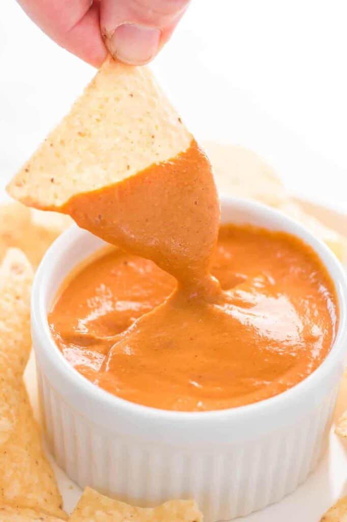 chip dipped in vegan queso