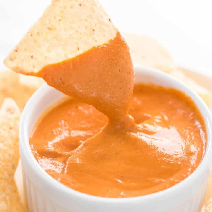 chip dipped in vegan queso