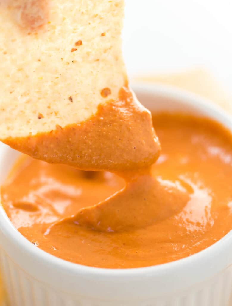 chip dipped in vegan queso