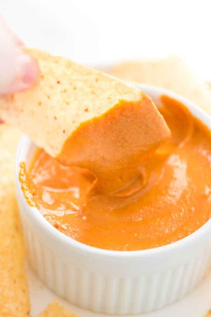 chip dipped in vegan queso