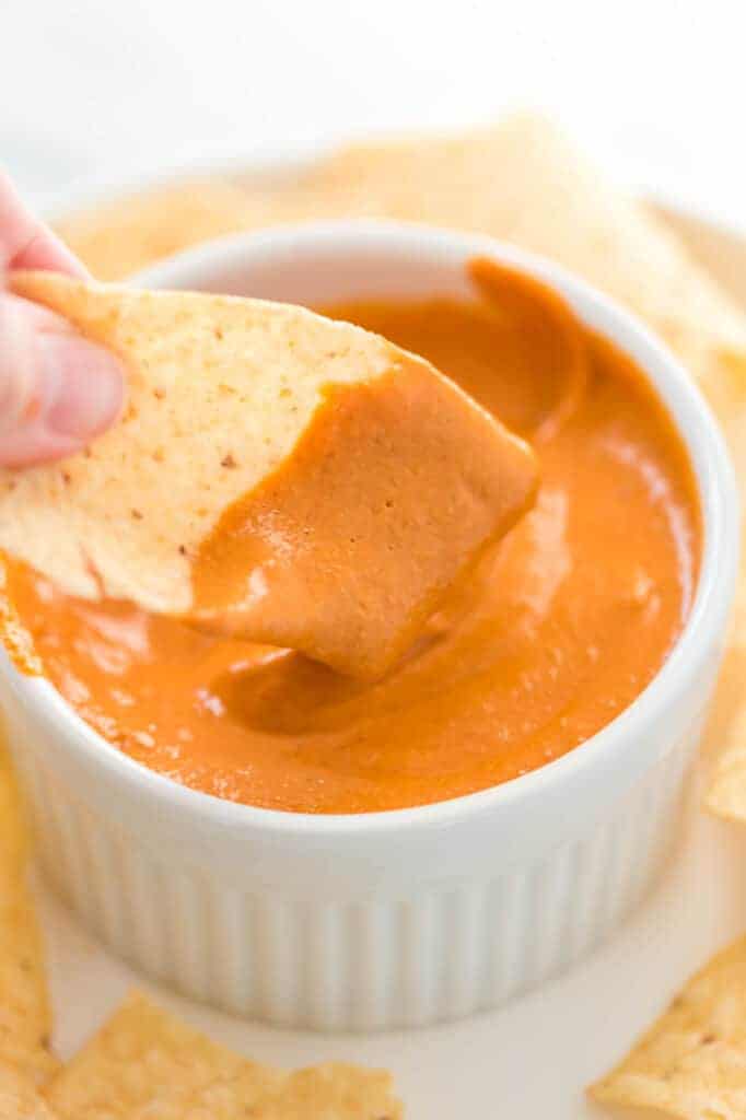 chip dipped in vegan queso