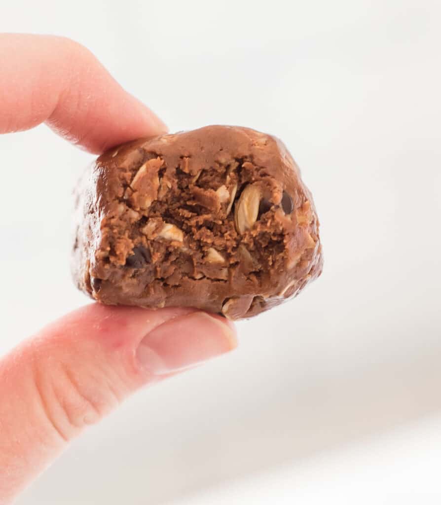 hand holding an energy ball with a bite taken out