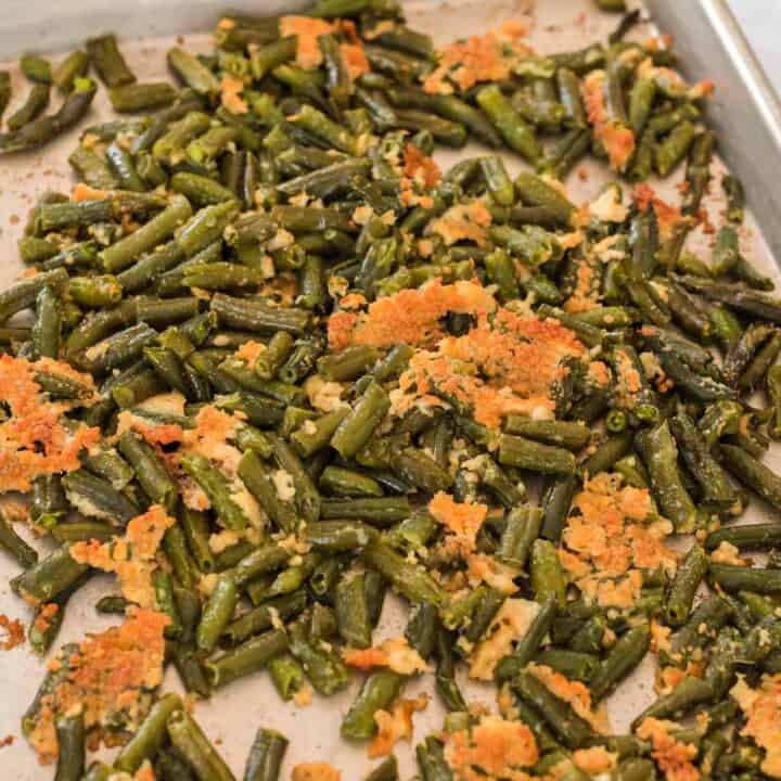 roasted green beans with parmesan on a baking sheet