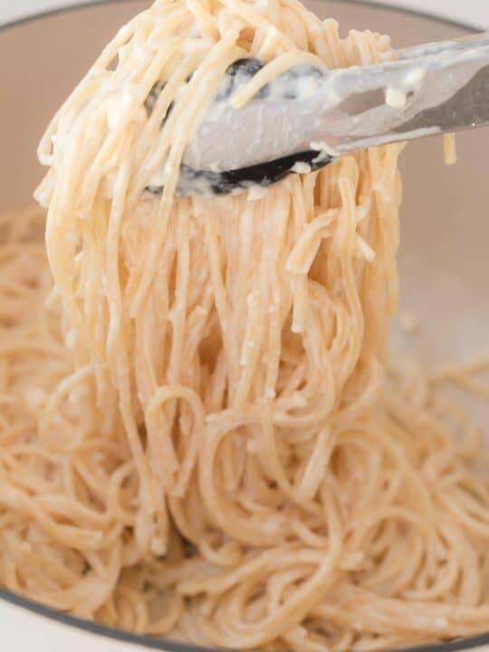 tons grabbing cream cheese spaghetti noodles from the pan