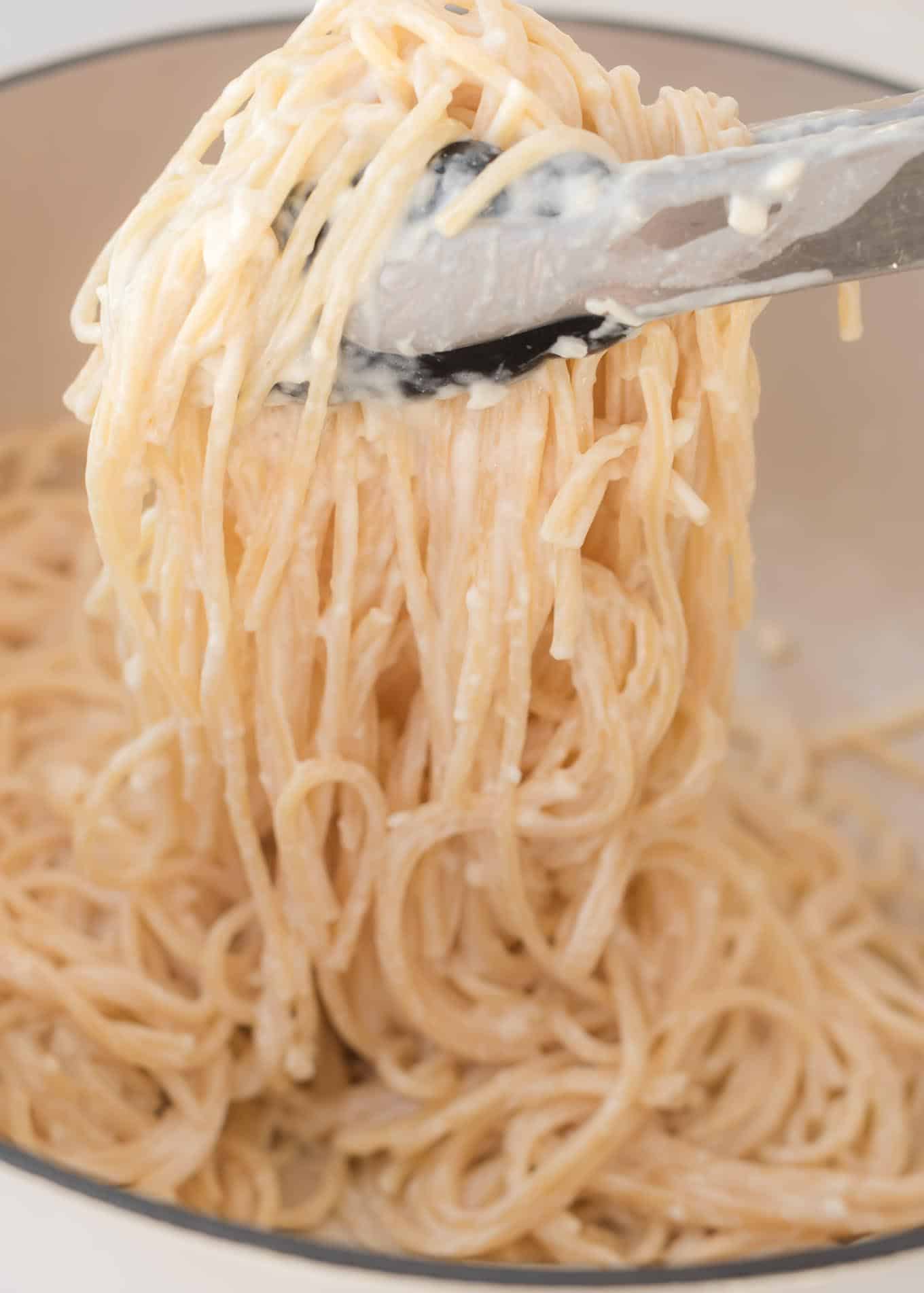 tons grabbing cream cheese spaghetti noodles from the pan