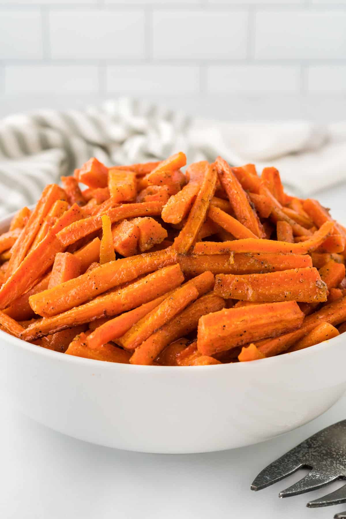 roasted carrots in a white serving bowl
