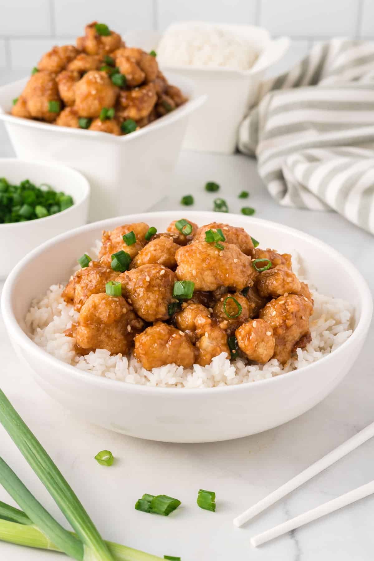 teriyaki cauliflower over rice in a white bowl