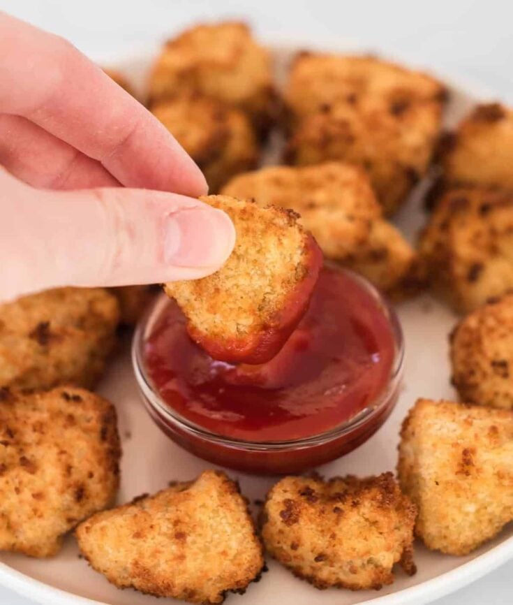 air fryer tofu nugget being dipped into ketchup