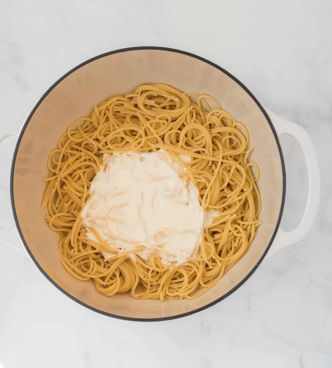 spaghetti noodles with cream cheese sauce poured on top