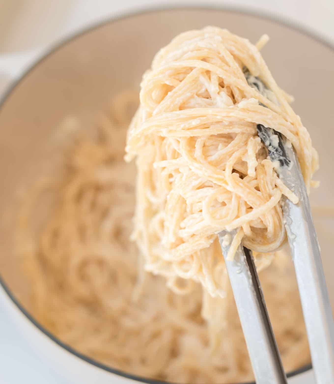 tons grabbing cream cheese spaghetti noodles from the pan