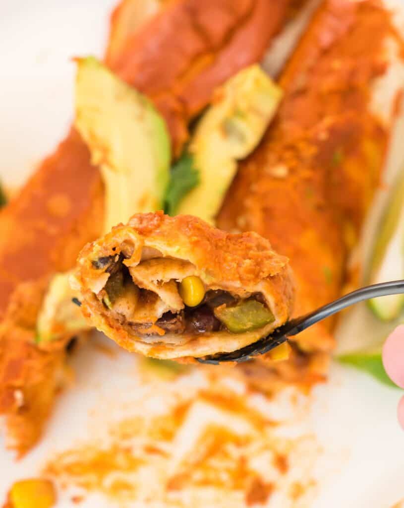 fork holding a bite of vegan enchilada