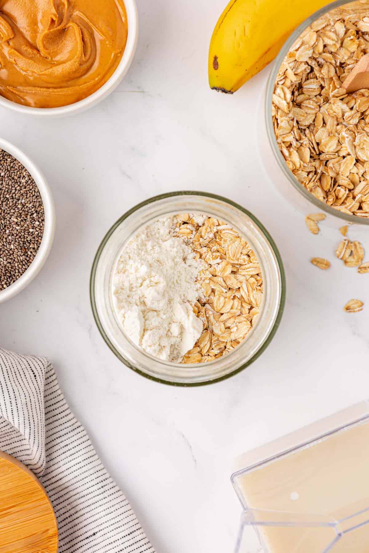 adding protein powder and oats to the jar