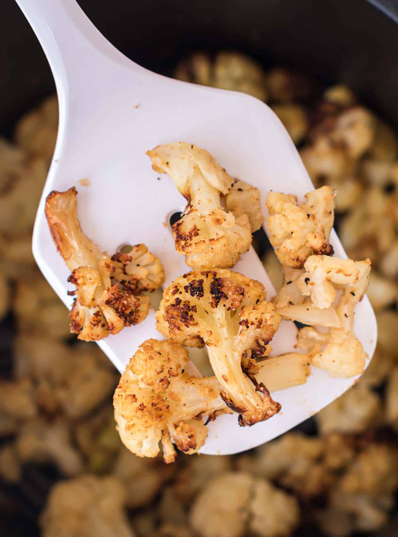 a spatula holding a scoop of air fryer frozen cauliflower