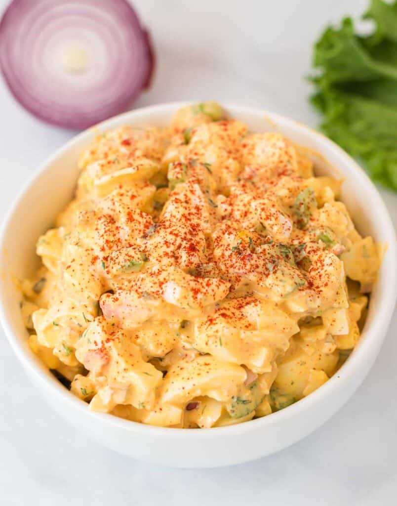 healthy egg salad in a white bowl sprinkled with paprika