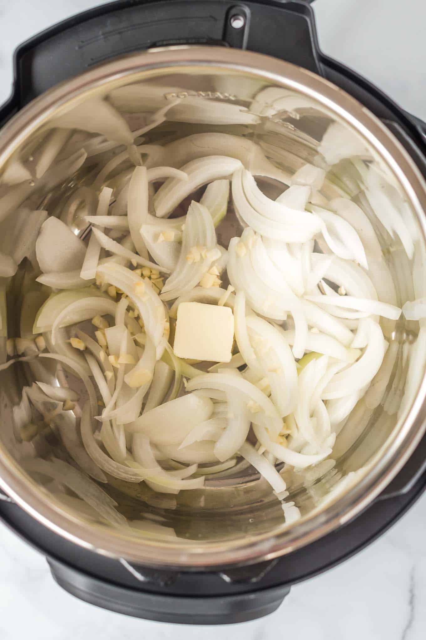 sliced onions, minced garlic, and butter inside an instant pot