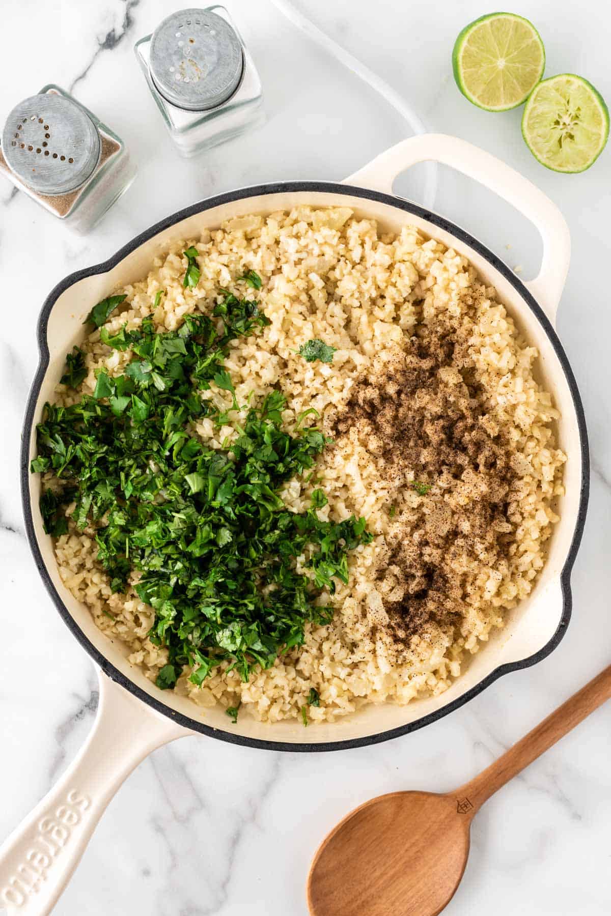 adding the cilantro, lime, and spices to the cauliflower rice