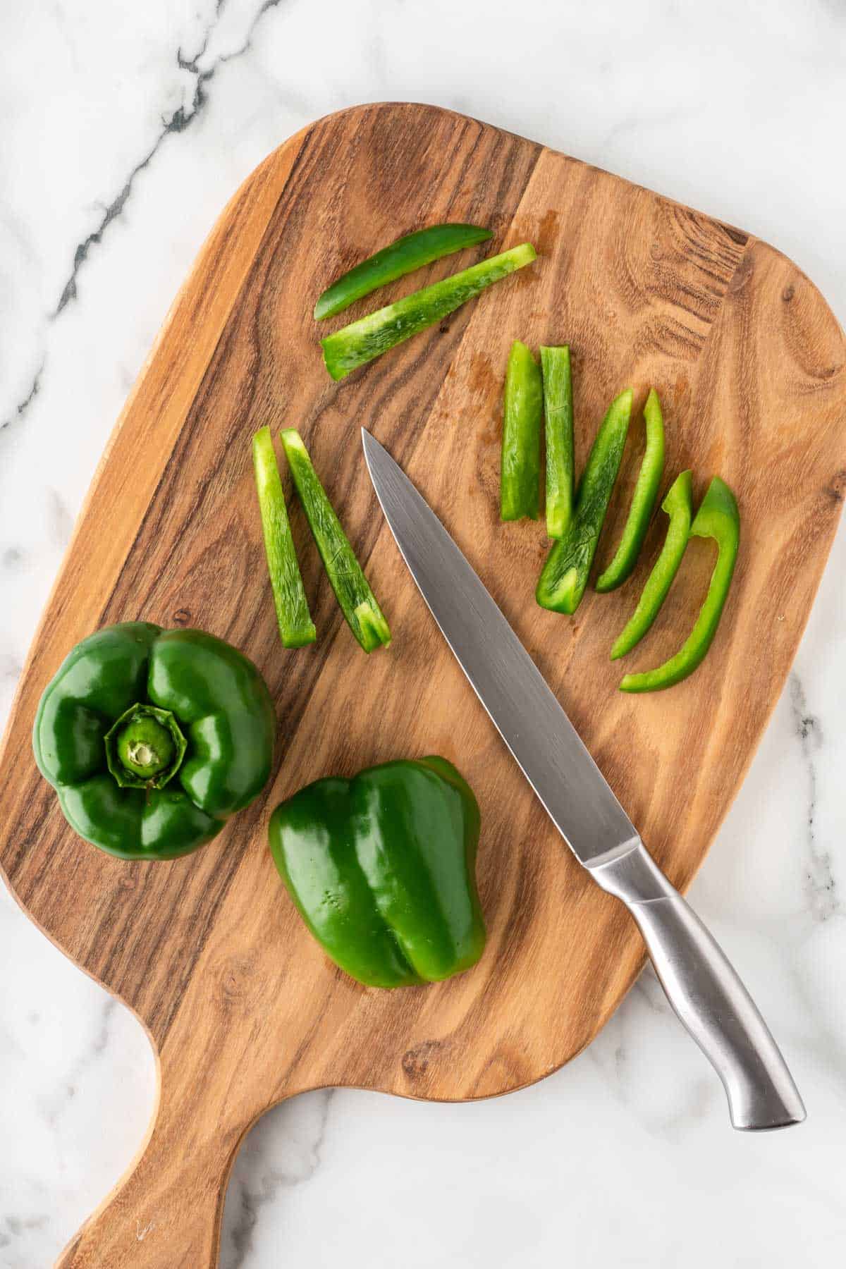 cutting green bell pepper into strips