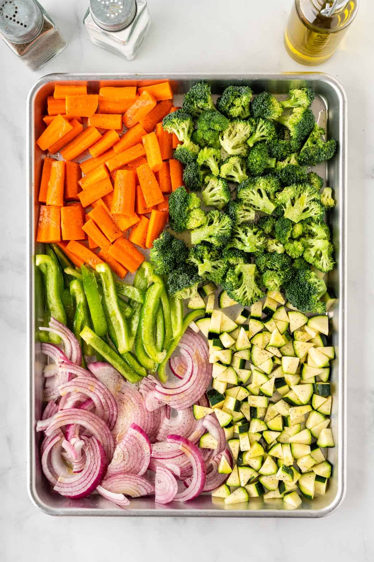 carrots, broccoli, bell peppers, onion, and zucchini on a baking sheet