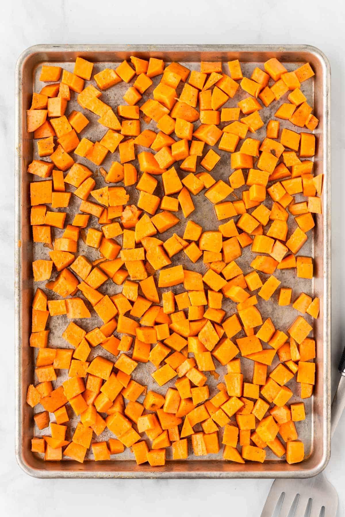 cubed sweet potato on a baking sheet