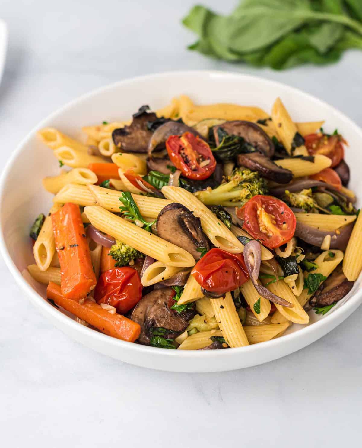 roasted vegetable pasta in a white bowl