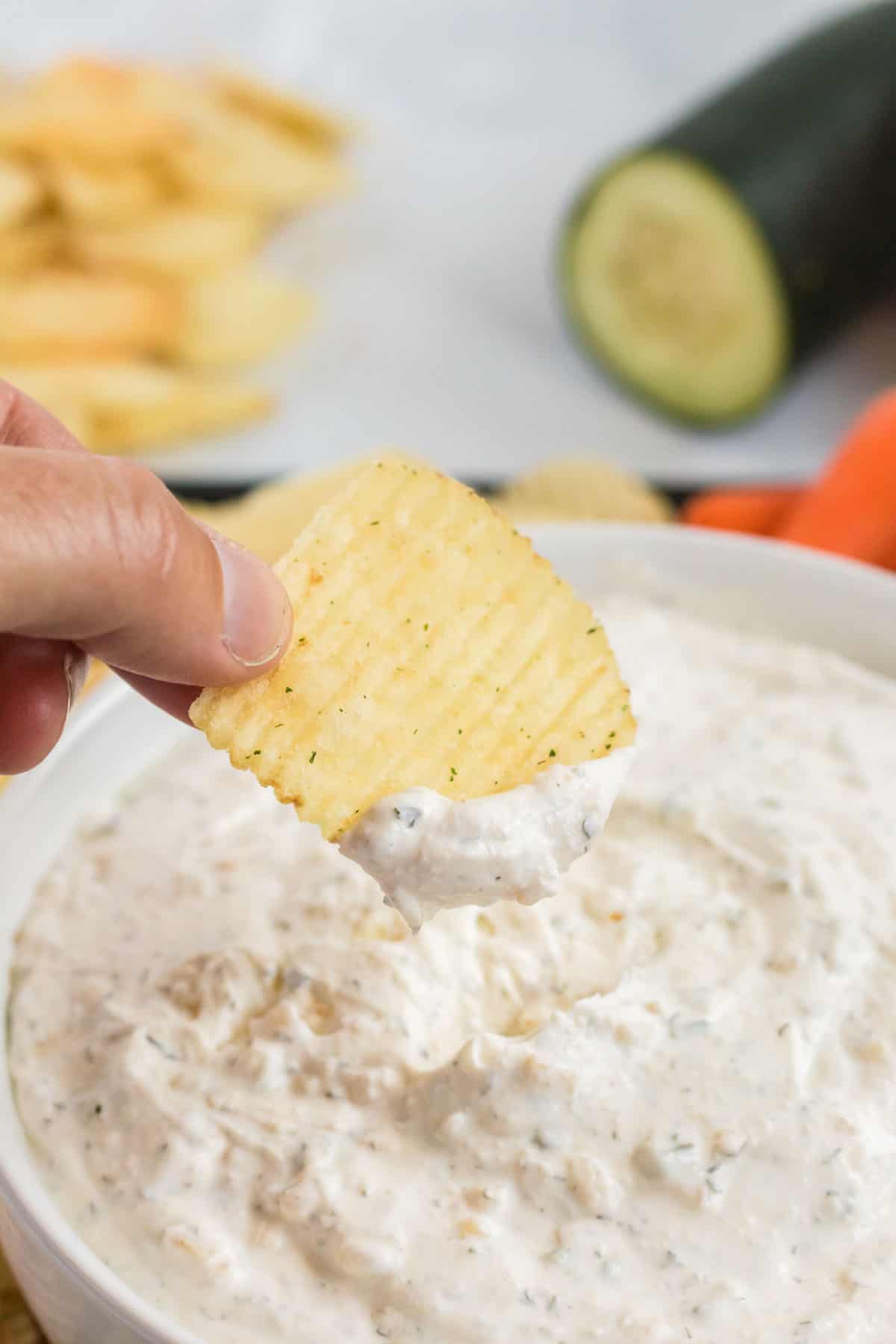 ruffle chip being dipped into chip dip